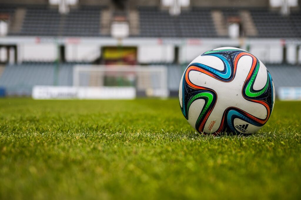 blue orange black green white adidas soccer ball on green field